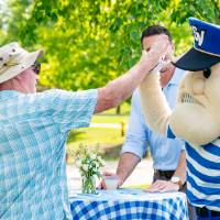 Louie high-fiving an alum who is surrounded by friends and family